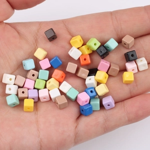 Hand holding colorful acrylic cube beads for DIY jewelry and phone chain making