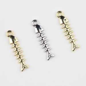 Detailed view of three gold and silver fishbone alloy pendants for DIY jewelry making