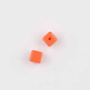 Detailed close-up of orange acrylic cube beads with smooth finish for DIY jewelry