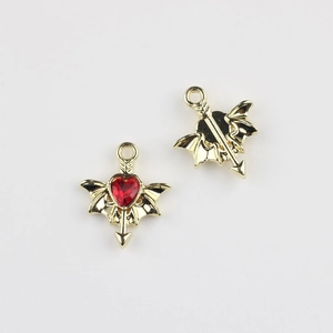 Detailed macro view of gold wing heart pendant with red gem for DIY jewelry making