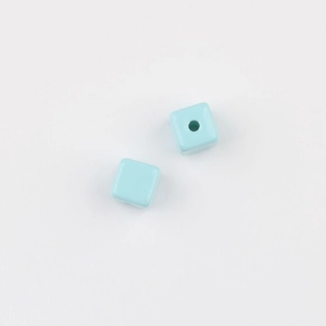 Detail of two light blue acrylic square cube beads with center holes for DIY jewelry