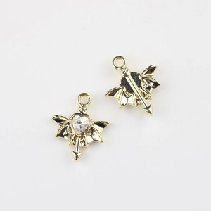 Detailed macro view of gold wing and heart pendant showing sparkling zircon inlay