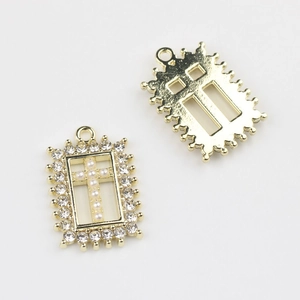 Detail voor- en achterkant van gouden kruishanger met parels en strass voor DIY-sieraden