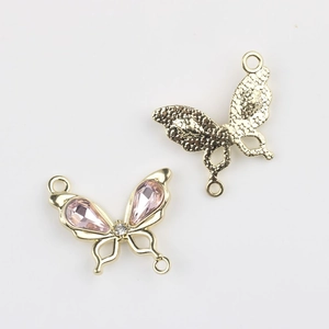 Detalle macro del colgante de lazo dorado con piedras rosas para la creación de joyas DIY