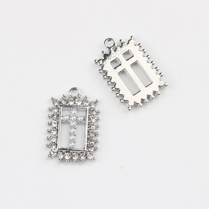 Detail van zilveren legering kruishanger met witte parels en strassteentjes voor DIY sieraden