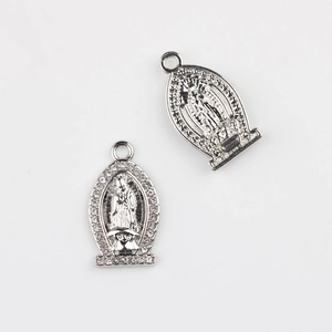 Macro detail of silver Virgin Mary charms with embedded zircons for DIY jewelry making