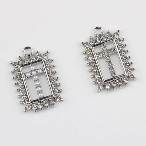 Gedetailleerd beeld van zilveren kruishangers met parels en strass voor DIY-sieraden