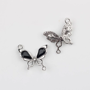 Detalle frontal y posterior del colgante de mariposa con piedras negras y cristales