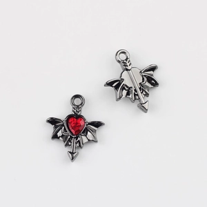Macro view of gun black winged heart charms with red zircon and arrow for DIY jewelry