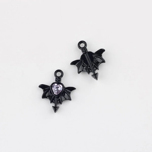 Macro shot of black alloy bat heart charms with pink zircon inlay for jewelry DIY