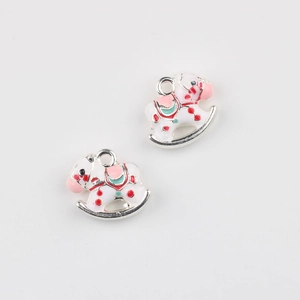 Detail of white enamel rocking horse charms with colorful accents for DIY jewelry making