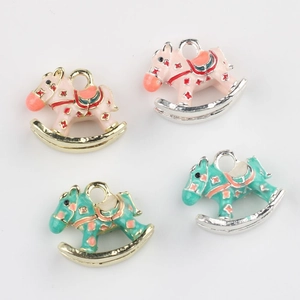 Close-up of alloy rocking horse pendants with pink and green enamel for DIY jewelry making