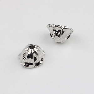 Detailed view of silver hollow flower petal bead caps for DIY jewelry making