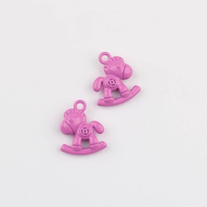 Dettaglio macro di due ciondoli a cavallo a dondolo rosa per la creazione di gioielli DIY