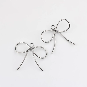 Primer plano de colgantes de lazo de aleación pulida para crear collares y pendientes DIY