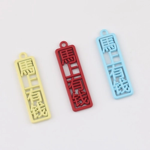 Nahaufnahme von drei bunten hohlen Glücksbringern mit chinesischen Zeichen für DIY-Schmuck