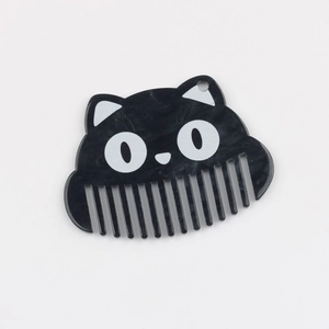 Vue détaillée du pendentif peigne chat en acétate avec texture marbre et motif 0.0