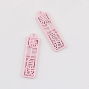 Nahaufnahme rosa rechteckiger Legierungsanhänger mit chinesischem Text für DIY-Schmuck