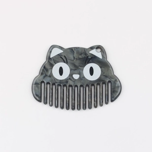 Vue détaillée du pendentif peigne en acétate gris marbré en forme de chat avec trou