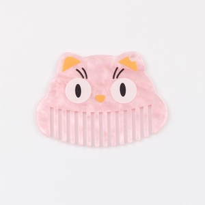 Détail d'un pendentif peigne en acétate rose marbré en forme de chat avec dents