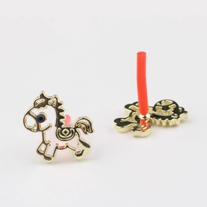 Detail van witte pony oorbellen met goudlaagje en rode rubberen beschermkapjes