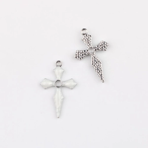 Details von silbernem Kreuzanhänger mit Hammerschlag und weißem Emaille-Kreuz