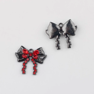 Detalle de colgante de lazo con pedrería roja y metal negro para creación de joyas DIY