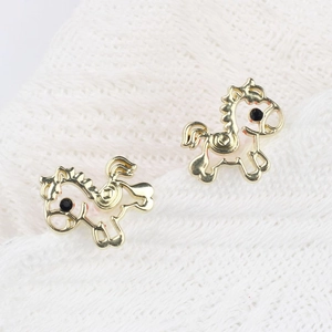 Minimalistische gouden pony oorknopjes met zirkoon op een witte getextureerde stof