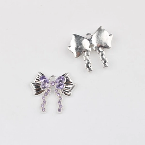 Detalle macro de colgantes de lazo con circonitas moradas para creación de joyas DIY