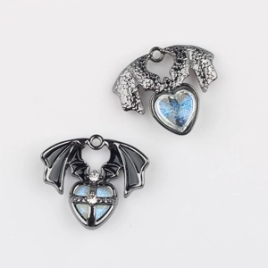 Macro view of bat wing heart charms with blue glitter and rhinestone inlay for DIY jewelry