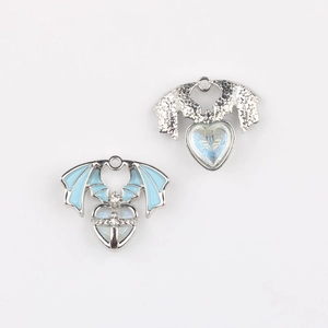 Detail of wing heart charms with blue enamel, cross inlay and silver star textures