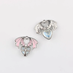 Close-up of wing heart pendants with enamel finish and zircon for DIY jewelry making