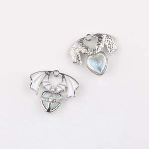 Detail of gothic bat wing heart charms with enamel inlay and rhinestone accents