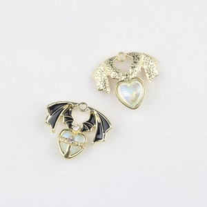 Detail view of heart-shaped bat wing charms with enamel and rhinestones for DIY jewelry
