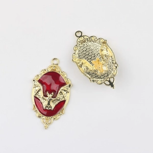 Detalle de colgantes de murciélago gótico con esmalte rojo y bordes dorados grabados