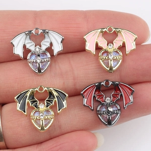 Gothic bat wing heart pendants with rhinestones in four colors held in hand