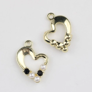 Macro detail of gold heart pendants with pearl and zircon inlay for DIY jewelry