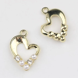 Macro detail of alloy heart charms with pearl and zircon inlay for DIY jewelry making