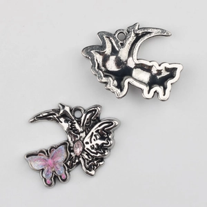 Détail de pendentif papillon et croissant de lune avec zircon rose et résine brillante