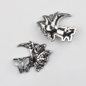 Détails des pendentifs papillon argentés avec reflets bleus et incrustation en résine noire