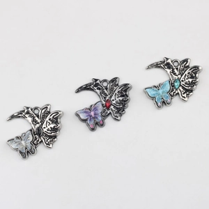 Détail macro de pendentifs papillon lune en alliage avec résine colorée et finition antique