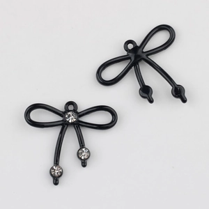 Detalle de colgantes de lazo negro para joyas DIY con incrustaciones de piedras de circón