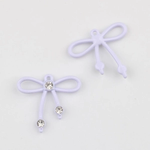 Detalle macro de colgantes de lazo esmaltado lavanda con engaste de circonitas brillantes
