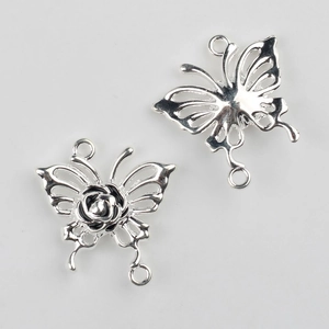 Detalle de colgantes de mariposa plateados con rosa para creación de joyas DIY