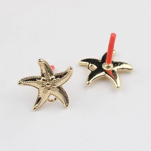 Détail de boucles d'oreilles étoile de mer dorées avec fini texturé et tiges en argent S925