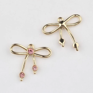 Detalle de colgantes de lazo para joyería DIY con cristales rosas y baño de oro
