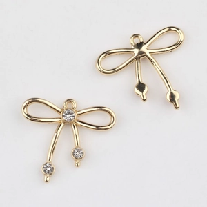 Detalle de colgantes de lazo dorado con circonitas y ganchos para creación de joyas DIY