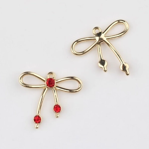 Detalle de colgante de lazo dorado con circonitas rojas para creación de joyas DIY