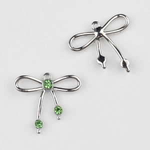 Detalle de colgante de lazo plateado con diamantes verdes para bisutería artesanal