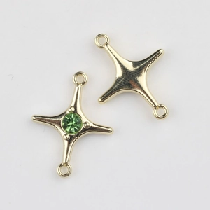 Detailed view of double-hook four-pointed star connectors with green gemstones for DIY jewelry